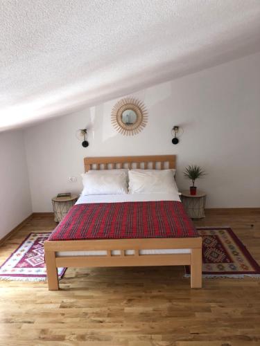 1 dormitorio con 1 cama con alfombra roja en Green Silence - Iva, en Danilovgrad