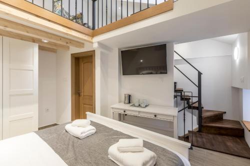 a room with a staircase with a tv and two stools at Cosmijeva Luxury Rooms in Split