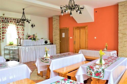 Bańska的住宿－Przy dzwonku，一间设有白色桌椅和橙色墙壁的客房