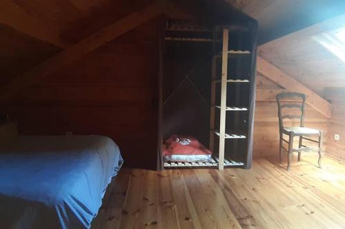 a bedroom with a bed and a chair in a attic at la cabane au fond du jardin in Arsac
