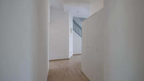 an empty hallway with white walls and wooden floors at Joyful Apartments Sopot in Sopot