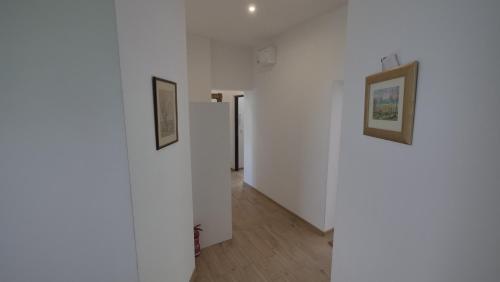 a hallway with white walls and paintings on the walls at Joyful Apartments Sopot in Sopot