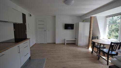 a kitchen and dining room with a table and a refrigerator at Joyful Apartments Sopot in Sopot