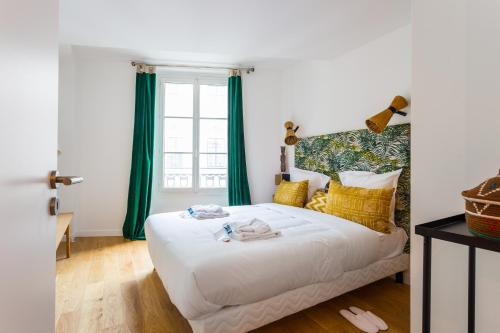 - une chambre avec un lit et des rideaux verts dans l'établissement Spacious apartment - 3BR-6P - Champs Elysées, à Paris