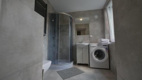 a bathroom with a shower and a washing machine at Joyful Apartments Sopot in Sopot