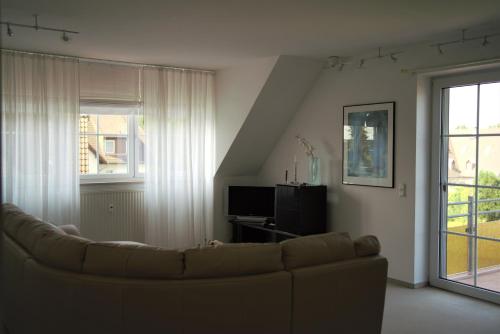 salon z kanapą i oknem w obiekcie Strandburg w Zingst