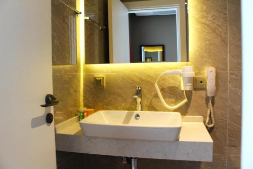 a bathroom with a white sink and a mirror at YURDAKUL HOTEL in Barbaros