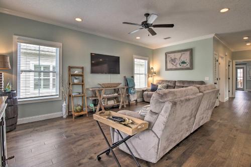 a living room with a couch and a ceiling fan at Modern and Spacious St Simons Home 4 Mi to Beach! in Ebo Landing