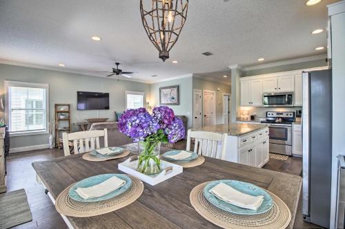 a kitchen and dining room with a table with purple flowers at Modern and Spacious St Simons Home 4 Mi to Beach! in Ebo Landing