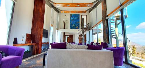 a living room with purple furniture and large windows at San Antonio Hotel Boutique in Santiago Matatlán