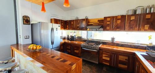 a kitchen with wooden cabinets and a stainless steel refrigerator at San Antonio Hotel Boutique in Santiago Matatlán