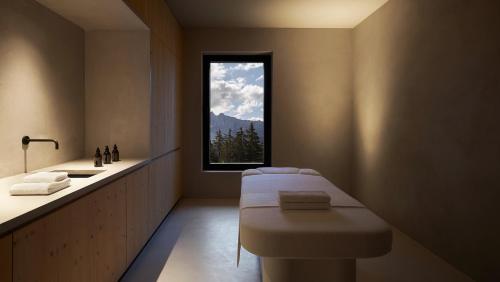 La salle de bains est pourvue d'une baignoire, d'un lavabo et d'une fenêtre. dans l'établissement Forestis Dolomites, à Bressanone