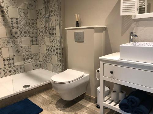 a white bathroom with a toilet and a sink at Maison La Viste in Dévillac