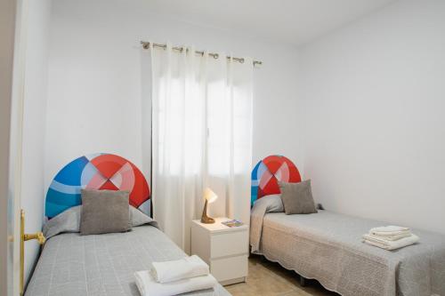 a bedroom with two beds and a lamp on a night stand at Villa Pancho in Playa Blanca