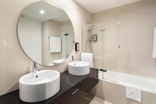 a bathroom with two sinks and a large mirror at Belmar Spa & Beach Resort in Lagos