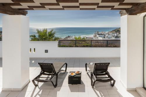 a patio with two chairs and a view of the ocean at Belmar Spa & Beach Resort in Lagos