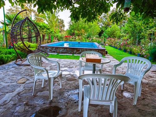 a patio with three chairs and a table and a swing at Danica House in Krivolak