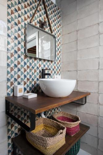 a bathroom with a sink and a mirror on a wall at El ático de los mosaicos in Cádiz
