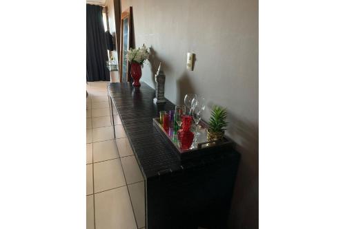 a black counter in a hallway with flowers on it at Studio Sublime West Flat Mossoró in Mossoró