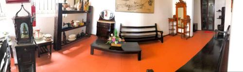 a living room with an orange floor and a table at Pousada Colonial Penedo - Alagoas in Penedo