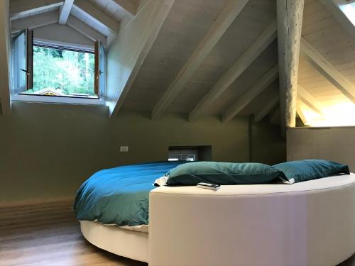 Casa Tifra في Breguzzo: غرفة نوم بسرير ونافذة