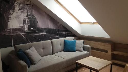 a living room with a couch and a skylight at Apartament Limanowskiego in Kraków