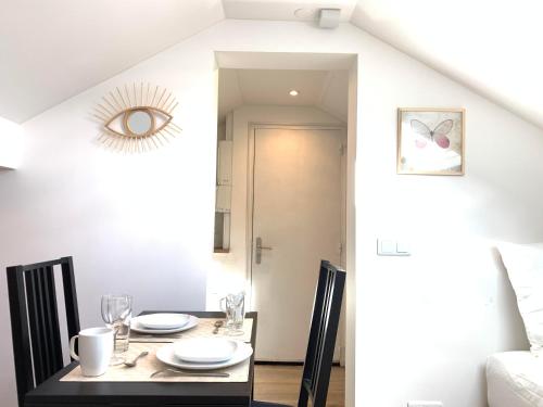 a dining room with a table with chairs and a mirror at Appart'Village Jouy Les Metz in Jouy-en-Josas