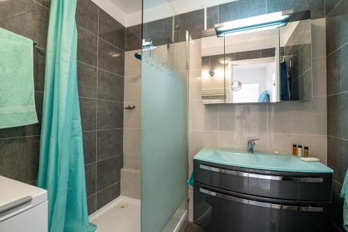 une salle de bain avec un lavabo et une douche dans l'établissement COPACABANA appartement 2 chambres, à Cannes
