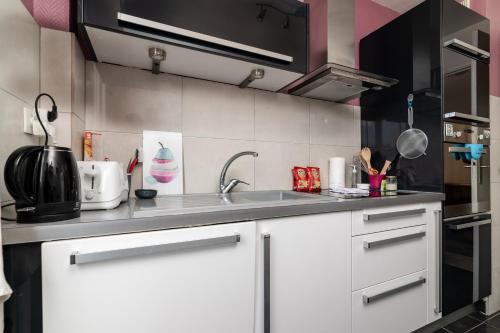 une cuisine avec des armoires blanches et un évier dans l'établissement COPACABANA appartement 2 chambres, à Cannes