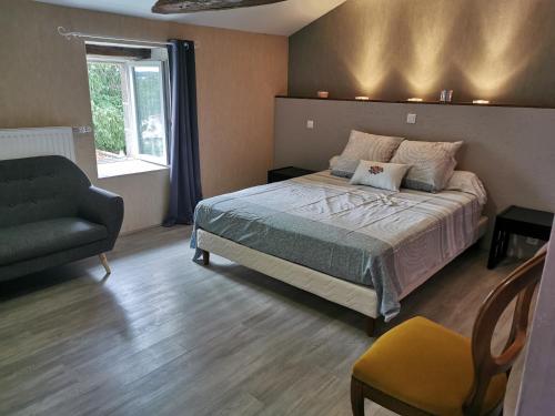 une chambre avec un lit, une chaise et une fenêtre dans l'établissement La Longère de Mina, à La Petite-Boissière