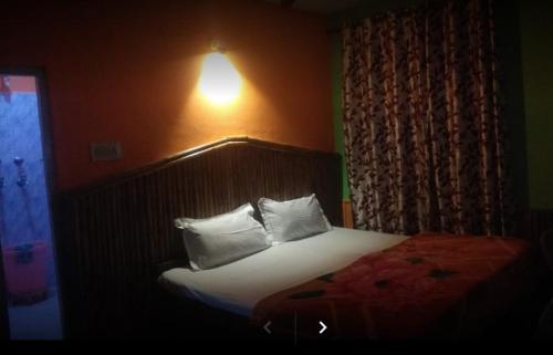a bedroom with a bed with white pillows at Shanti Cafe and Guest House Mcloedganj in Dharamshala