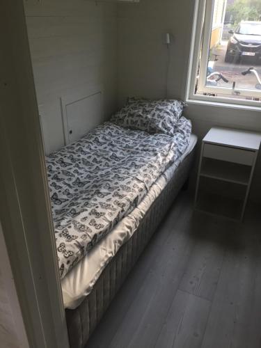 Bett in einem kleinen Zimmer mit Fenster in der Unterkunft Annexet in Jönköping