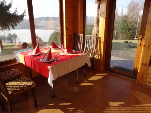 a table in a room with a red table cloth at Country Houses Vidų Sodyba in Utena