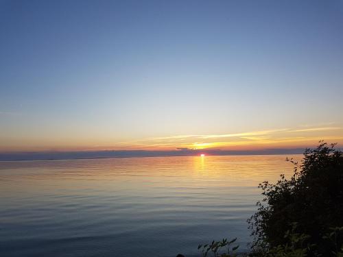 a sunset over a large body of water at Sjötorpet - unikt boende vid havet på norra Öland! in Löttorp