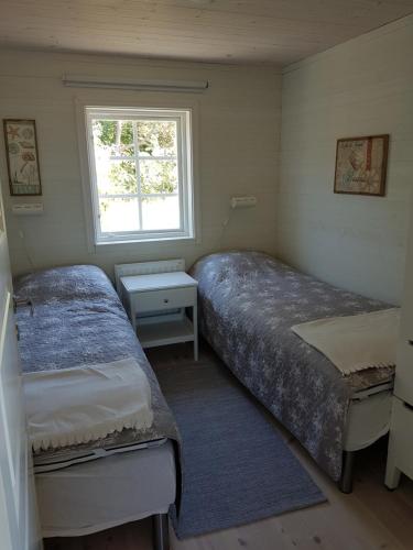 a bedroom with two beds and a window at Sjötorpet - unikt boende vid havet på norra Öland! in Löttorp