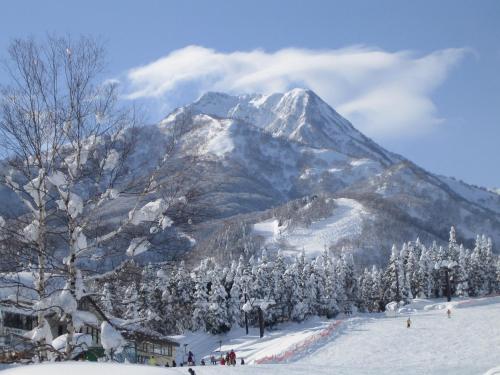 a snow covered mountain in front of a ski slope at Akakura Wakui Hotel in Myoko
