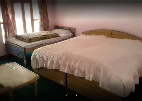 A bed or beds in a room at Tridev (Triveni) Hotel and Restaurant