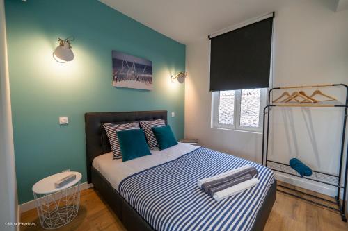 a bedroom with a bed with blue and green walls at L'île de la Brèche in Niort