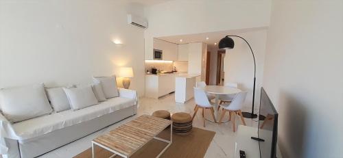 a living room with a white couch and a table at Quinta do Lago Beach House in Quinta do Lago