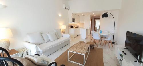 a living room with a white couch and a table at Quinta do Lago Beach House in Quinta do Lago