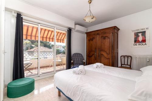 une chambre avec deux lits et une grande fenêtre dans l'établissement COPACABANA appartement 2 chambres, à Cannes