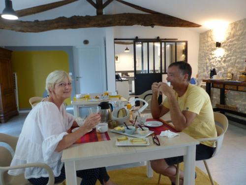un homme et une femme assis à une table dans l'établissement L'Alambic De L'Estuaire, à Saint-Fort-sur-Gironde