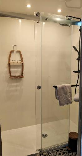 a shower with a glass door in a bathroom at Les Kabanes de Kerforn in Crach