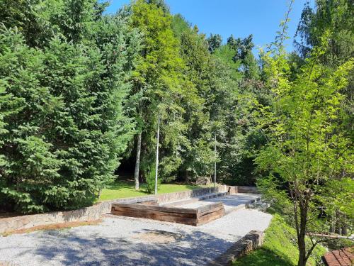 a garden with a stone wall and trees at Počitniška hiša Parkfield Dragovan in Metlika