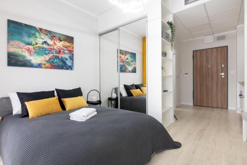 華沙的住宿－Yellow Sunset Studio，一间卧室配有一张带黄色枕头的大床