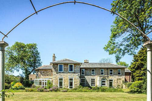 an archway in front of a large stone house at Cosy Wolf Bed & Breakfast in Freshwater