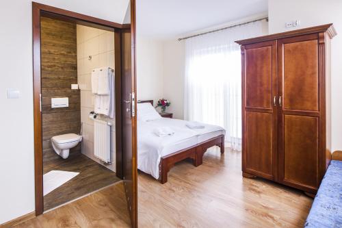 een slaapkamer met een bed en een toilet in een kamer bij BABIOGÓRSKA B&B in Zubrzyca Górna