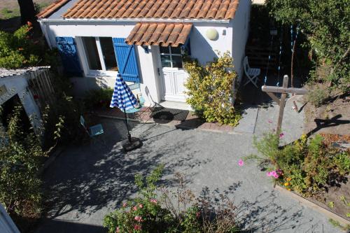 una pequeña casa con una bandera delante de ella en Petit studio CYPRÈS du BOIS en Noirmoutier-en-l'lle