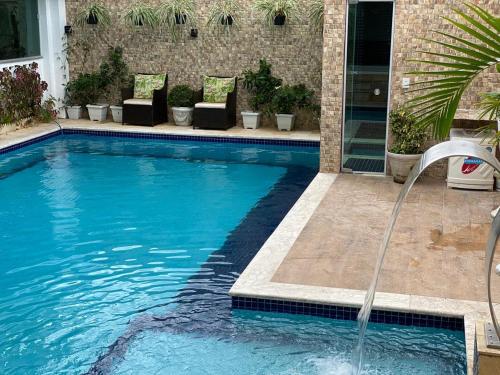 a swimming pool with a water fountain at Hotel Antiga Roma in Belém