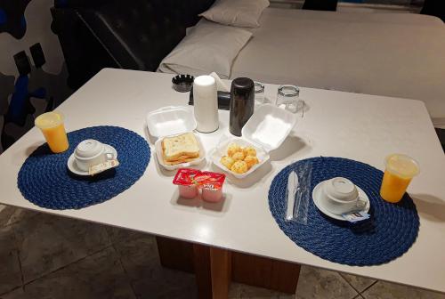 uma mesa com dois pratos azuis de comida em Motel Ilha de Capri em São Bernardo do Campo